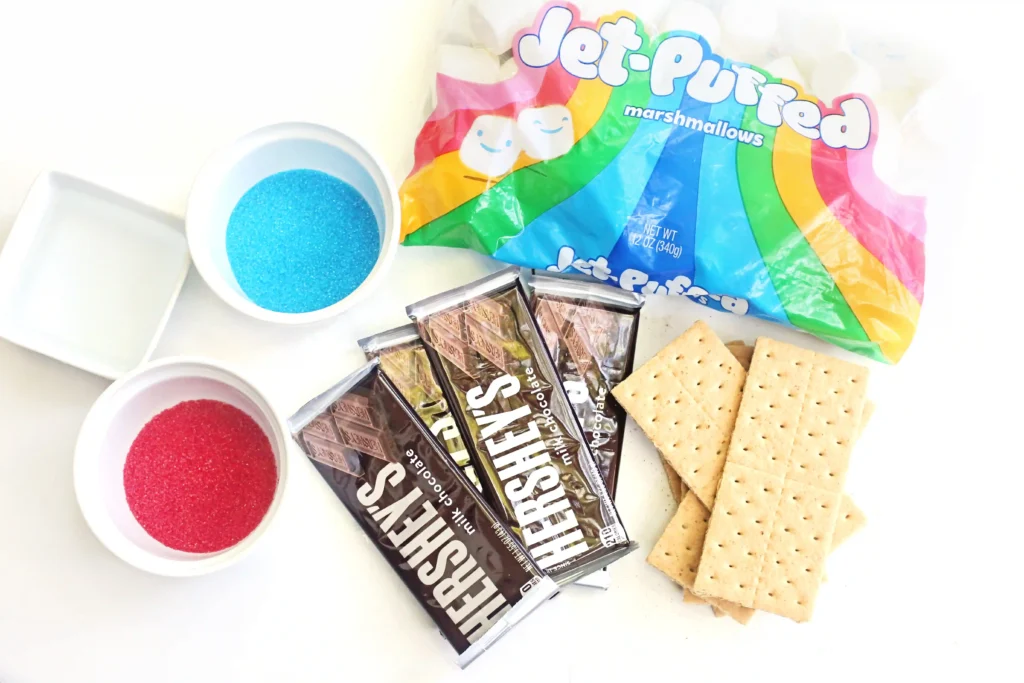 ingredients for the Patriotic S'mores Dip: red and blue sanding sugar, chocolate bares, marshmallows, and graham crackers