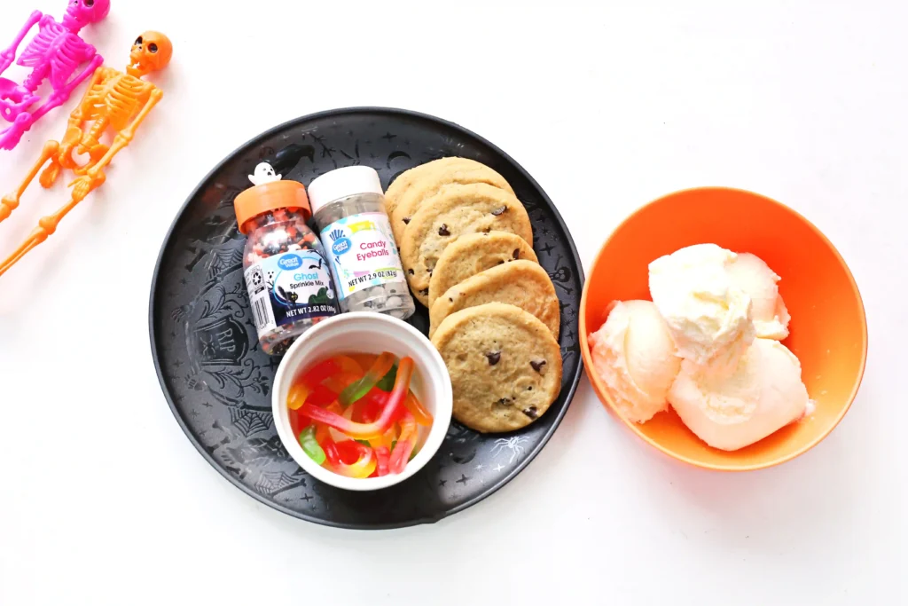 ingredients for this summerween dessert - chocolate chip cookies, vanilla ice cream, halloween sprinkles, and gummy worms