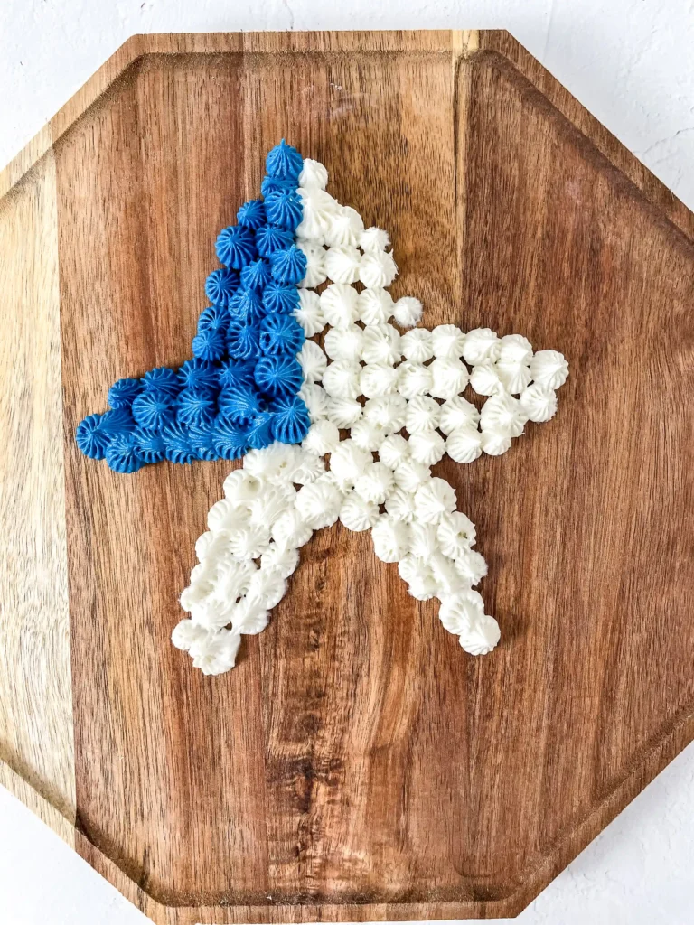 Blue and white piped rosettes arranged on a wooden octagonal board, forming a triangular cluster.