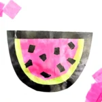 a watermelon suncatcher made of contact paper, construction paper, and tissue paper