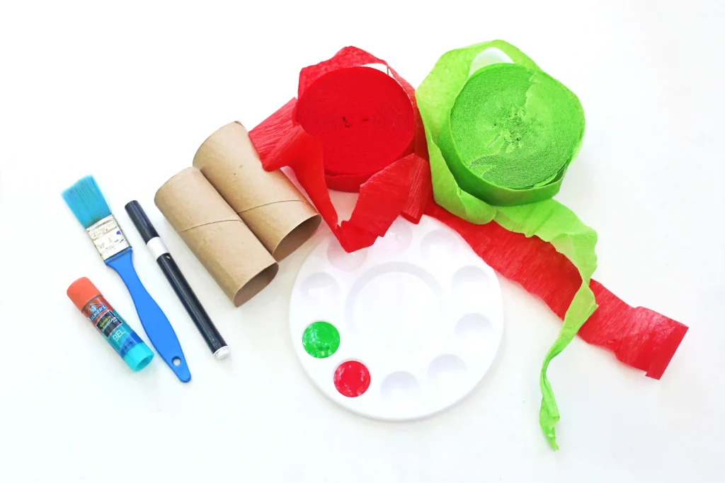 red and green streamers, toilet paper rolls, red and green paint, a black marker, glue, and a paint brush