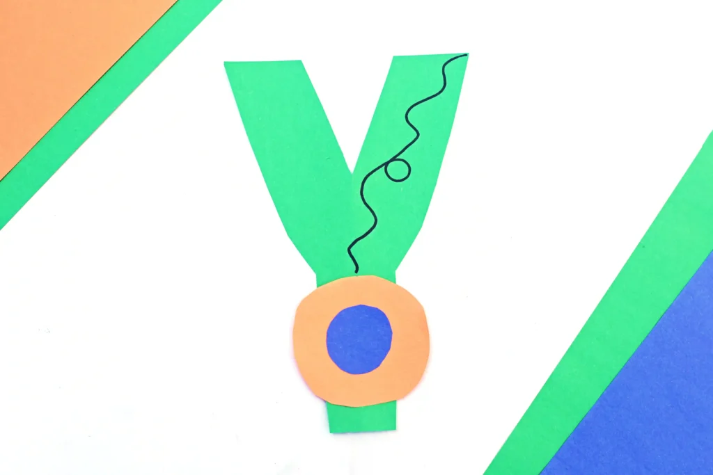 a letter y craft that has a letter y cut out of green construction paper and a construction paper yoyo attached