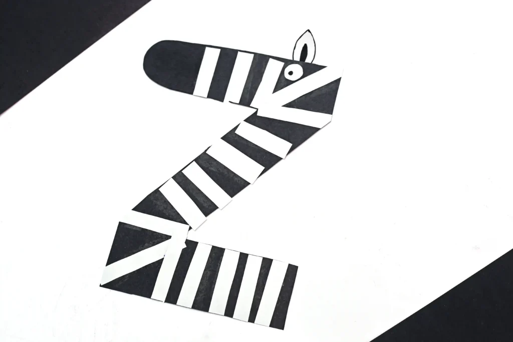 an alphabet craft for preschool that is a letter z cut out of black construction paper with white stripes