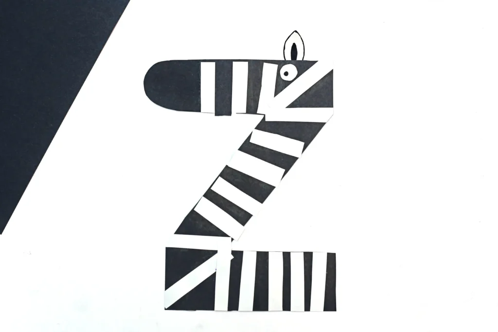 an animal alphabet craft that is a letter z cut out of black construction paper with white stripes