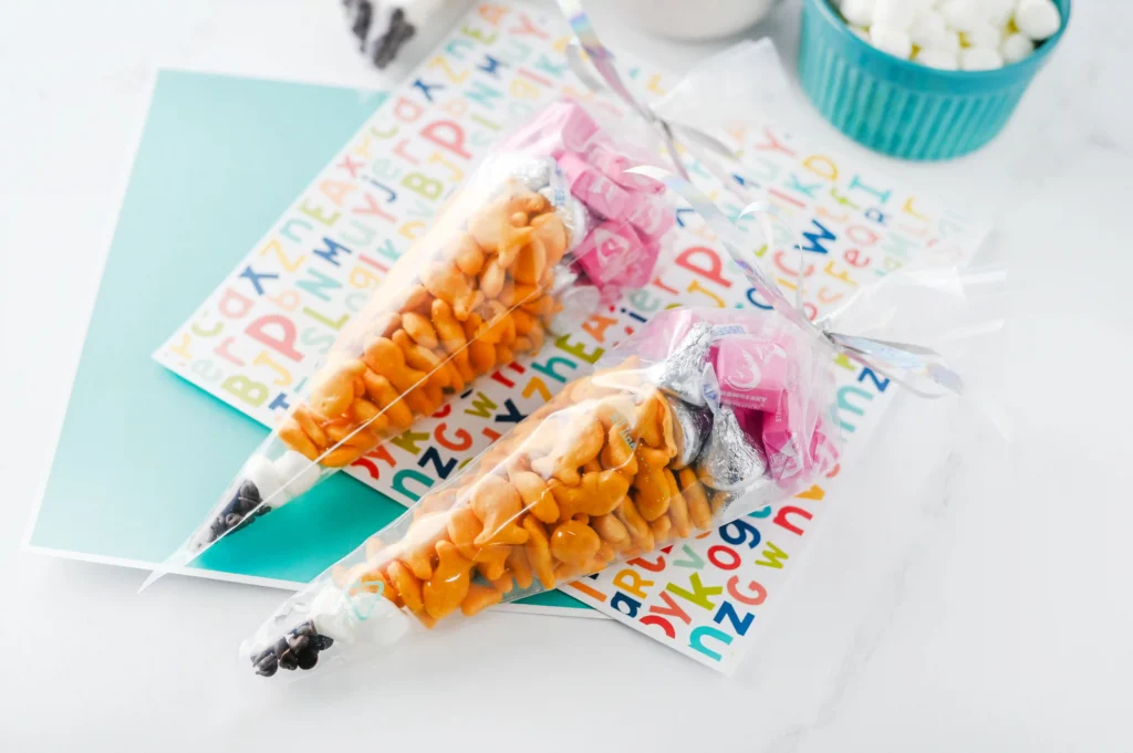 Pencil Treat Bags that are stuffed with kid-friendly snacks and candy in the color order to look like a pencil