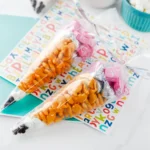 Pencil Treat Bags that are stuffed with kid-friendly snacks and candy in the color order to look like a pencil