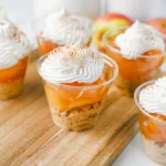 apple pie in a cup with a graham cracker crust, apple pie filling, and cool whip on top
