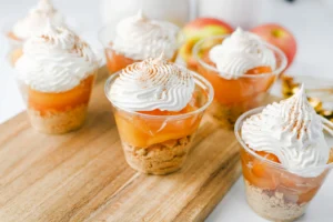 apple pie in a cup with a graham cracker crust, apple pie filling, and cool whip on top