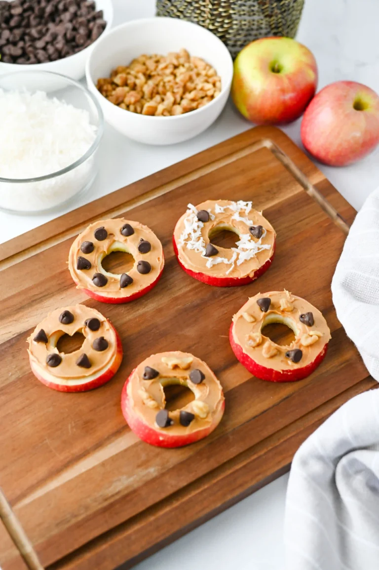Apple Slice Cookies with peanut butter, chocolate chips, and coconut flakes on a wooden board