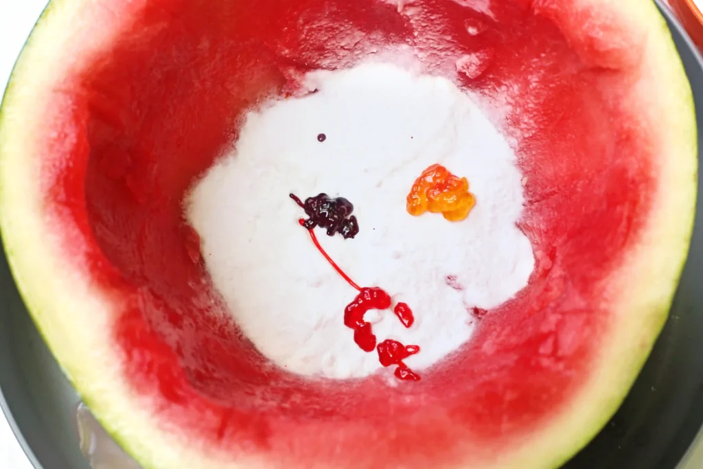 a hollowed out watermelon with baking soda and food coloring inside
