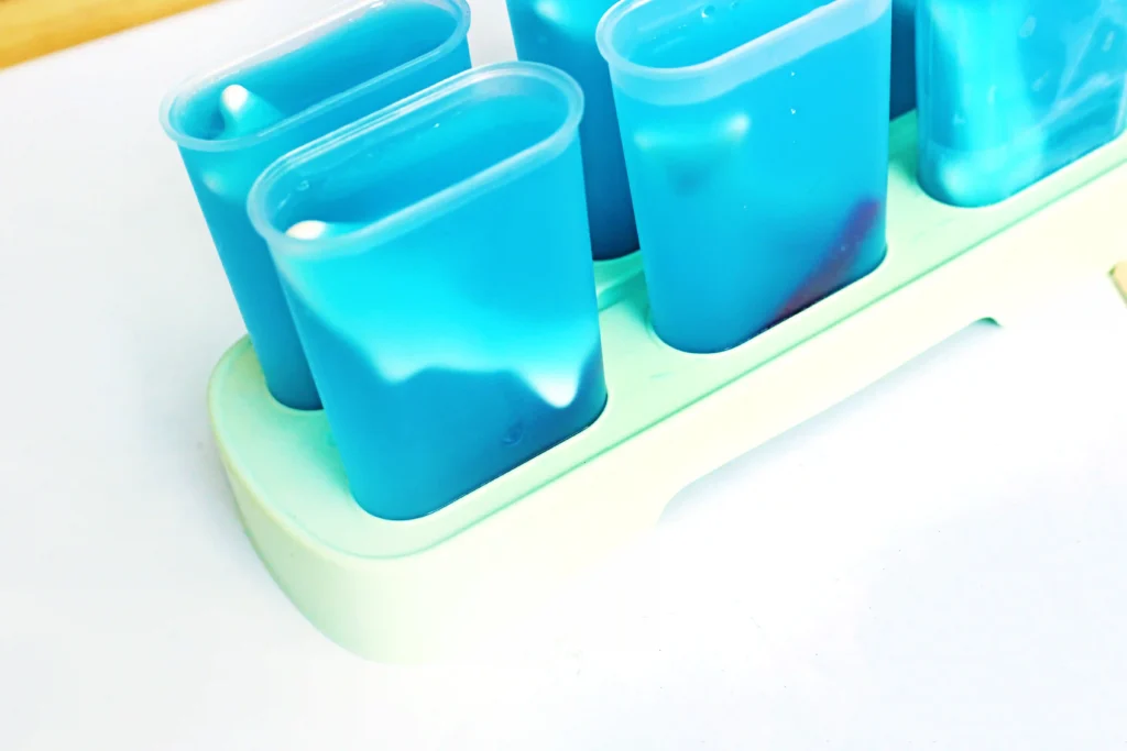 a popsicle recipe that uses blue raspberry lemonade with gummy sharks and swedish fish