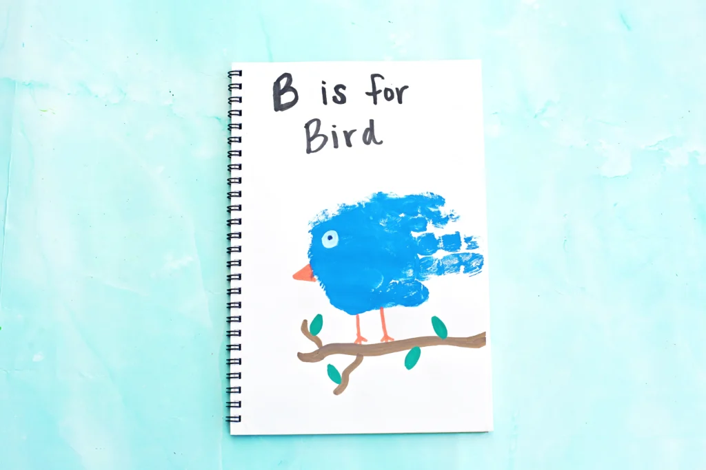 a letter b activity of a bird craft that is a blue handprint with a bead and eye to look like a bird with the words "b is for bird" written above it.