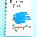 a letter b handprint craft that is a blue handprint with a bead and eye to look like a bird with the words "b is for bird" written above it.
