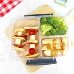 a Backyard Picnic Lunch Idea that has veggie and cheese kabobs, broccoli, and apples with peanut butter
