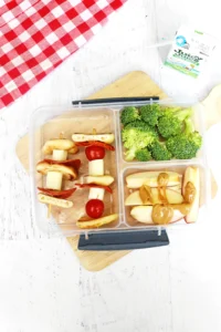 a Backyard Picnic Lunch Idea that has veggie and cheese kabobs, broccoli, and apples with peanut butter