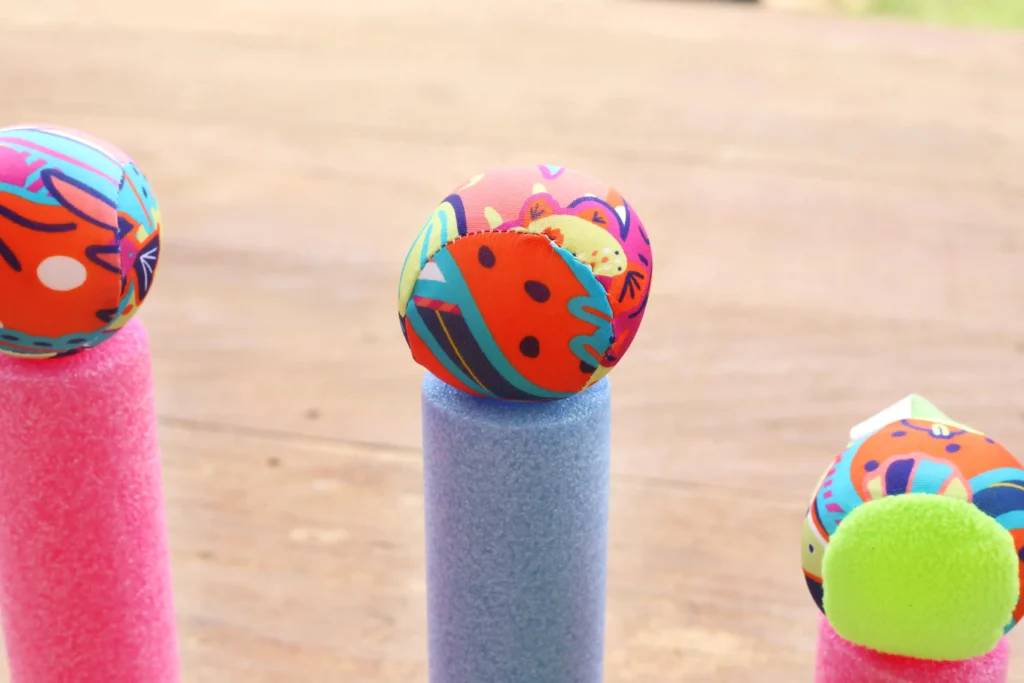 Outdoor Water Play Activity - Cultivating Brilliant Minds a water ball resting on top of a blue pool noodle