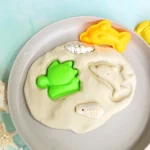 sand playdough recipe with beach toys and shells pressed in