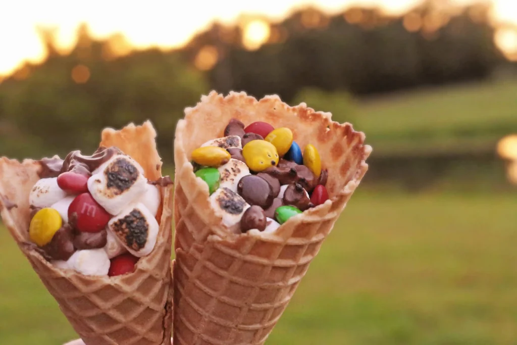 Campfire S'mores Cones that have marshmallows, chocolate chips, and m&ms in a waffle cone