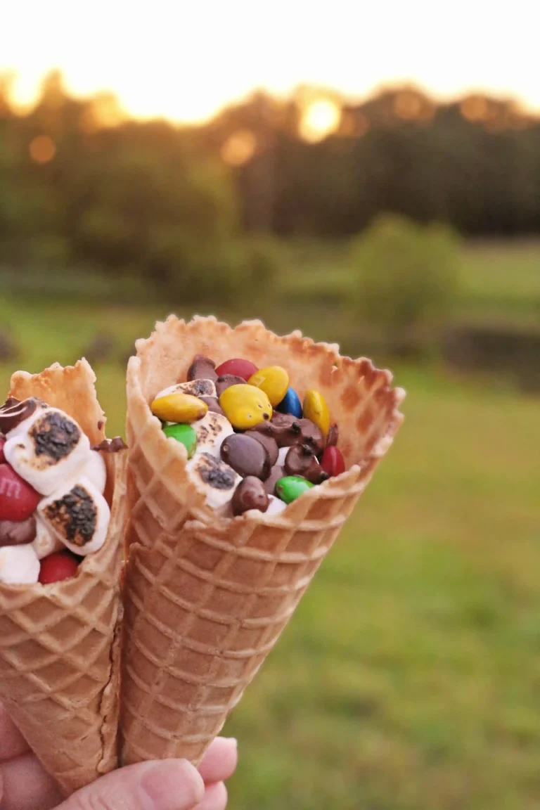 S'mores recipe that have marshmallows, chocolate chips, and m&ms in a waffle cone