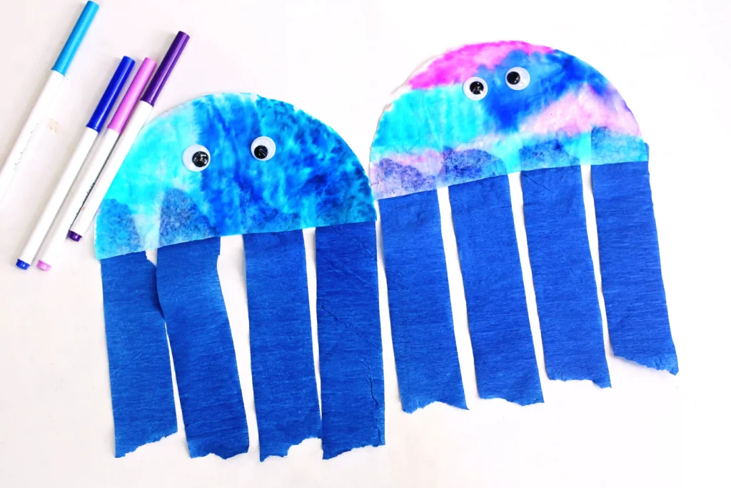 Coffee Filter Jellyfish Craft - Cultivating Brilliant Minds a Coffee Filter Jellyfish Craft with a coffee filter colored iwth blue, pink, and purple markers and blue streamers for the jellyfish tentacles
