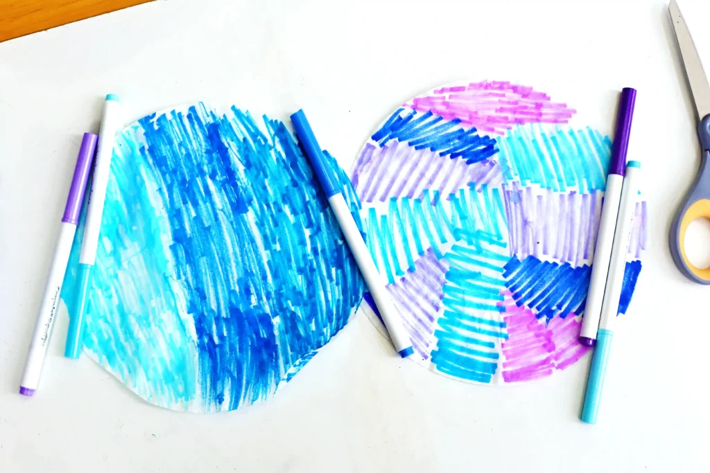 Coffee Filter Jellyfish Craft - Cultivating Brilliant Minds coffee filters colored with pink, purple, and blue markers