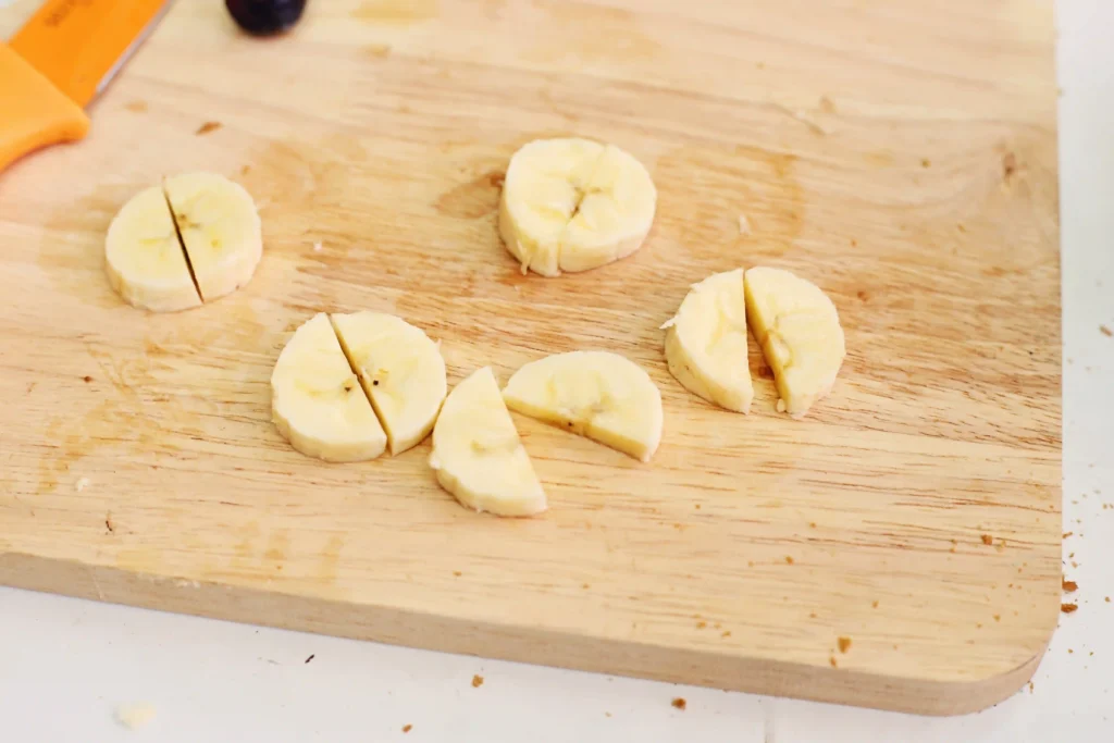 Banana slices arranged on a light wooden cutting board