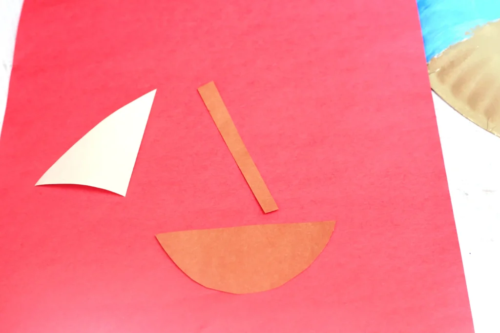 boat pieces cut out of construction paper for this beach paper plate craft