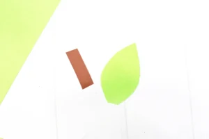 a rectangle cut out of brown construction paper and a leaf cut out of green construction paper
