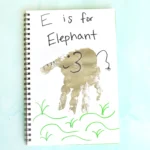 a letter e handprint craft that is a grey handprint with details to look like an elephant