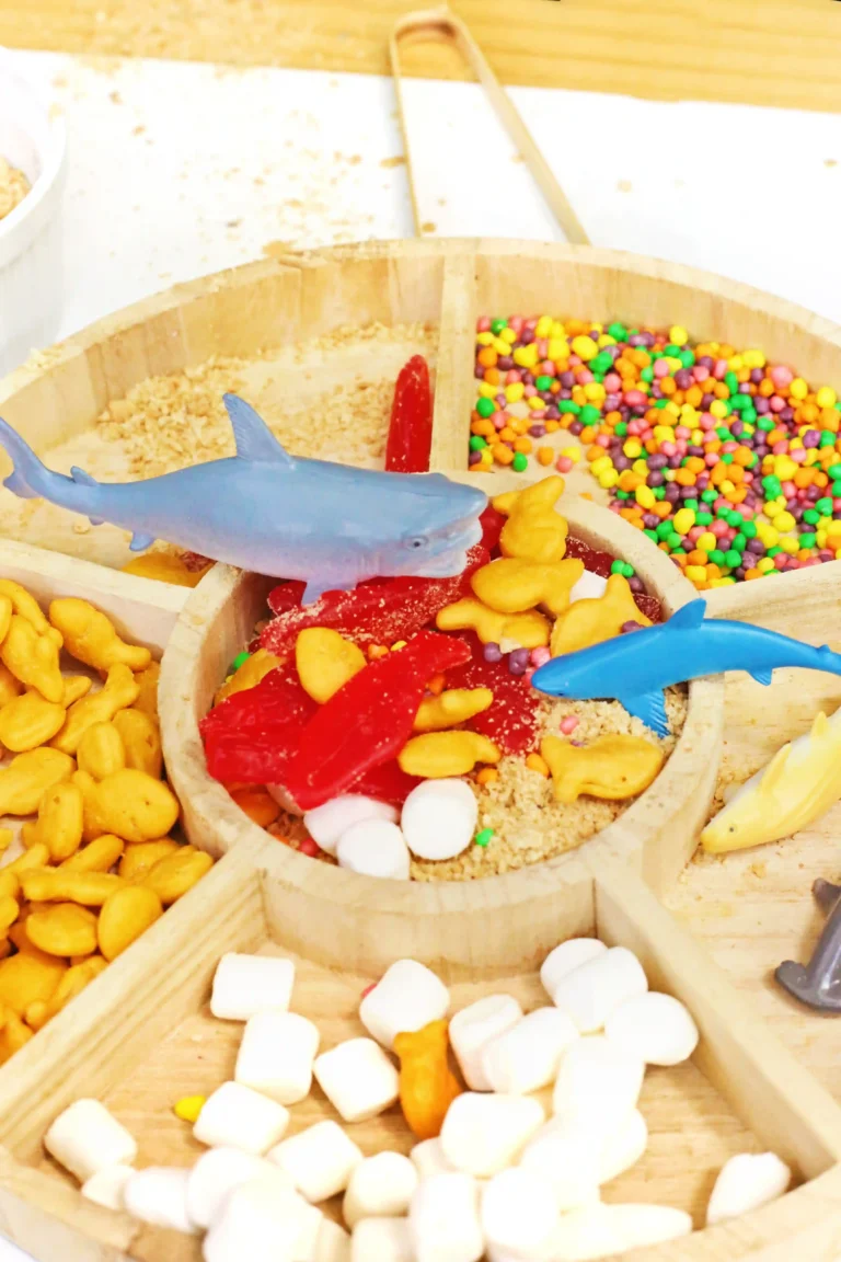 an Edible Shark Bait Sensory Bin with goldfish crackers, nerds, swedish fish, marshmallows, and toy sharks
