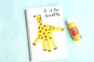 a letter g handprint craft that is a yellow handprint decorated to look like a giraffe with words "G is for giraffe"