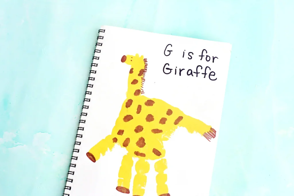 a letter g handprint craft that is a yellow handprint decorated to look like a giraffe with words "G is for giraffe"