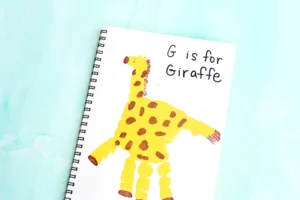 a letter g handprint craft that is a yellow handprint decorated to look like a giraffe with words "G is for giraffe"