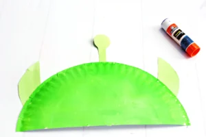 a paper plate cut in half and painted green with green construction paper ears and an antenna