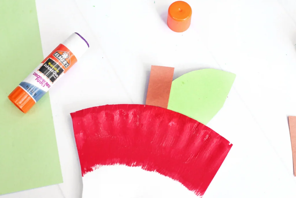 an Apple Core Paper Plate Craft that has a paper plate cut and painted to look like an apple core