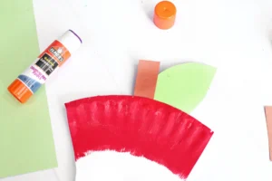 an Apple Core Paper Plate Craft that has a paper plate cut and painted to look like an apple core