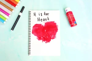 a Letter H Handprint Craft that uses two red handprints to make a heart