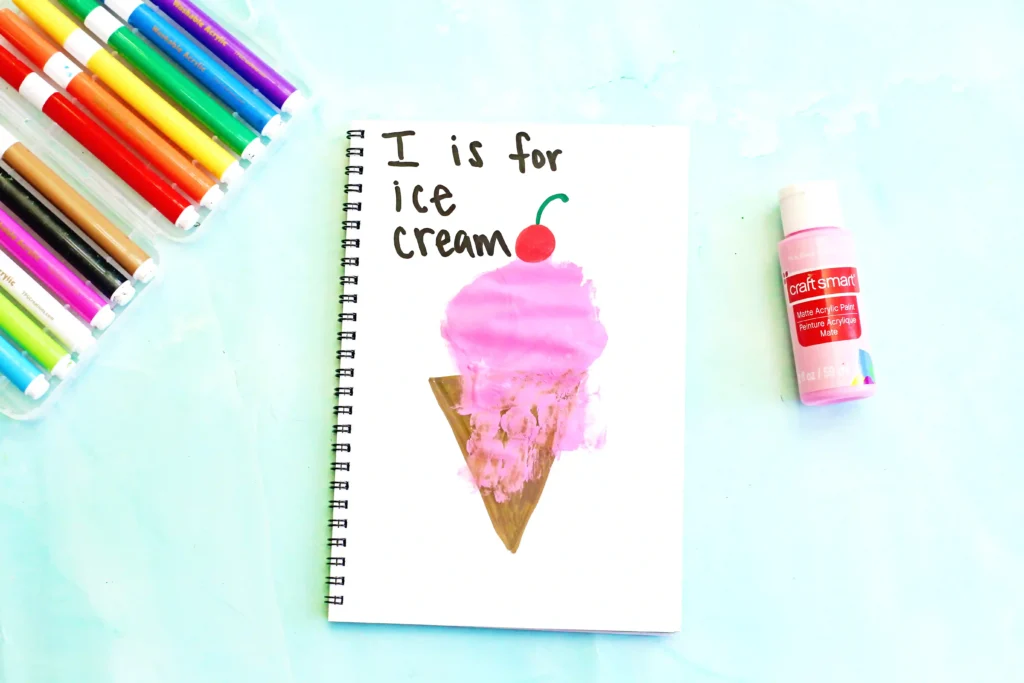 a letter I handprint craft that is an ice cream cone with a pink ice cream handprint, a cherry, and the words :I is for ice cream"