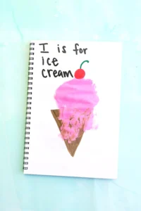 a letter I handprint craft that is an ice cream cone with a pink ice cream handprint, a cherry, and the words :I is for ice cream"