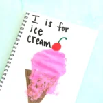 an I is for ice cream handprint craft that is an ice cream cone with a pink ice cream handprint, a cherry, and the words :I is for ice cream"