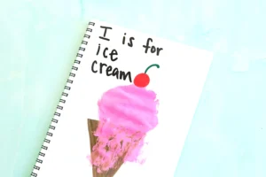 an I is for ice cream handprint craft that is an ice cream cone with a pink ice cream handprint, a cherry, and the words :I is for ice cream"