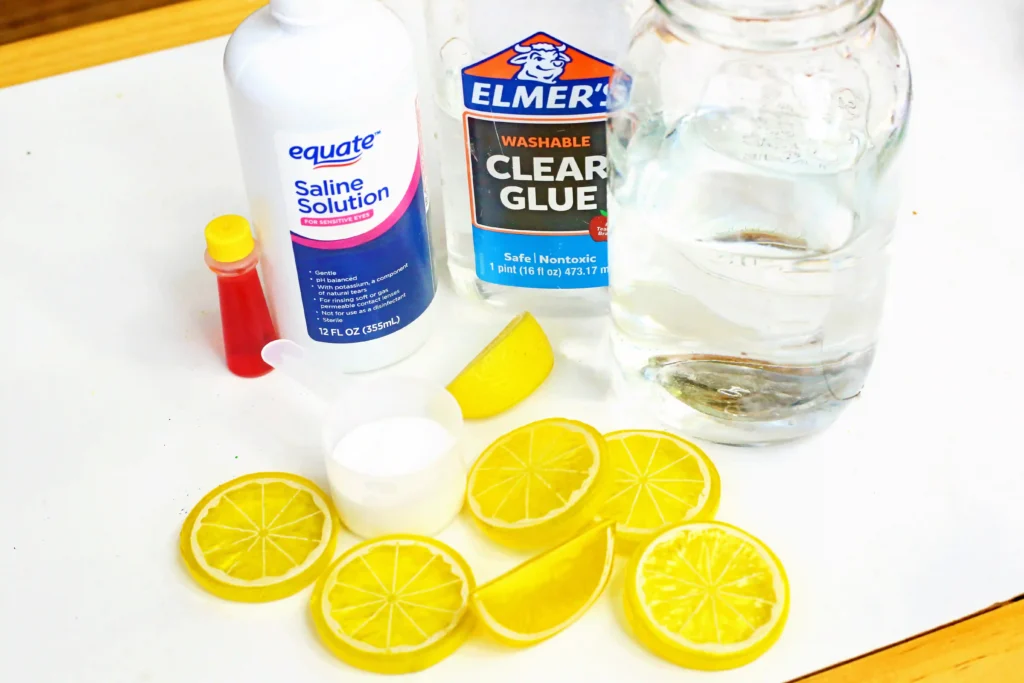 Lemon Slime - Cultivating Brilliant Minds ingredients for this slime recipe - plastic lemons, clear glue, water, yellow food coloring, and saline solution