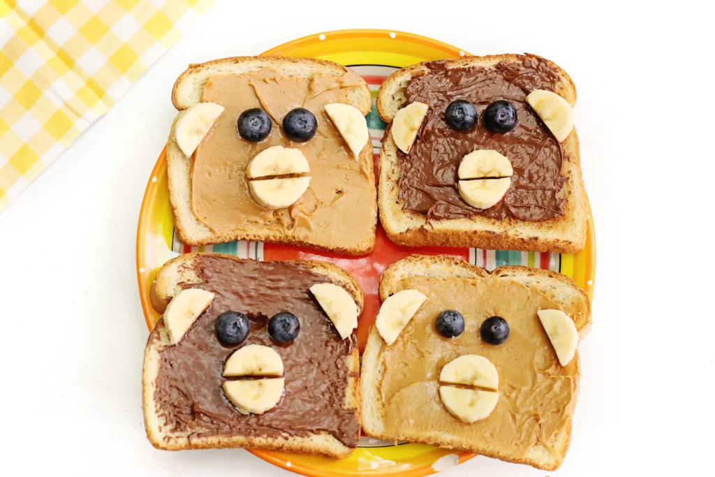 Monkey Face Toast made out of bread, peanut butter and chocolate hazelnut spread, bananas, and blueberries