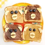 Monkey Face Toast made out of bread, peanut butter and chocolate hazelnut spread, bananas, and blueberries