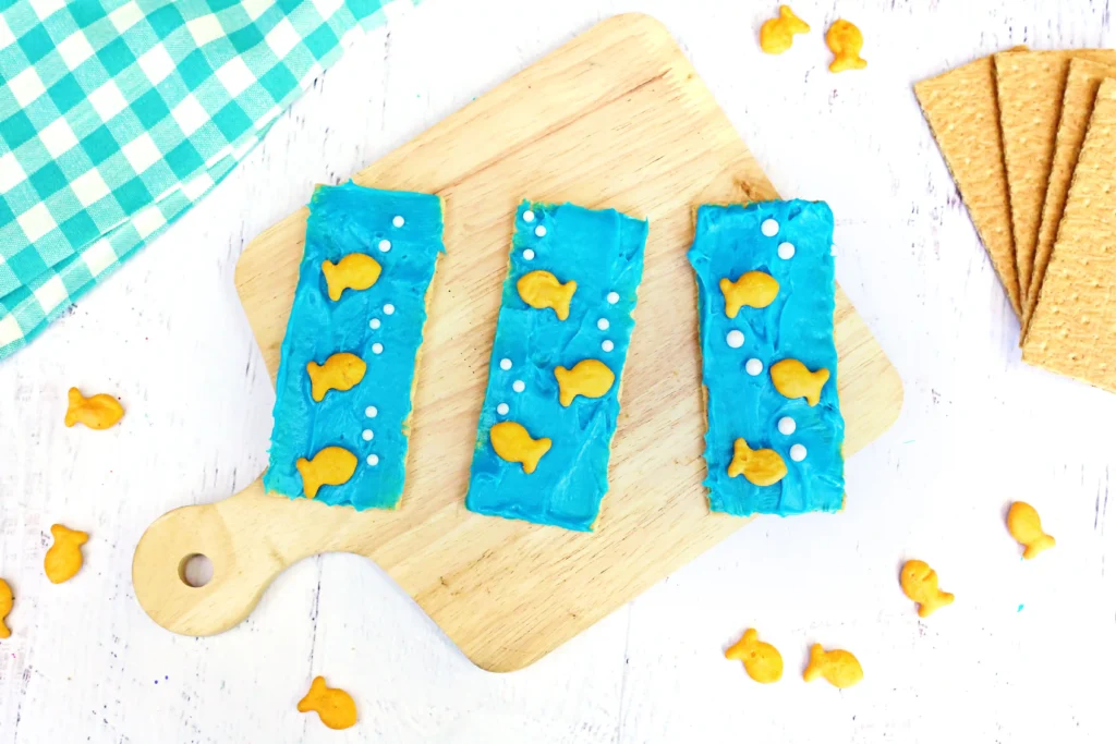 Ocean Graham Crackers - Cultivating Brilliant Minds Ocean Graham Crackers that are graham crackers with blue frosting, goldfish crackers, and sprinkles