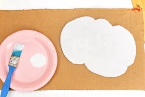a piece of cardboard cut into the shape of a cloud and painted white for this spring activity