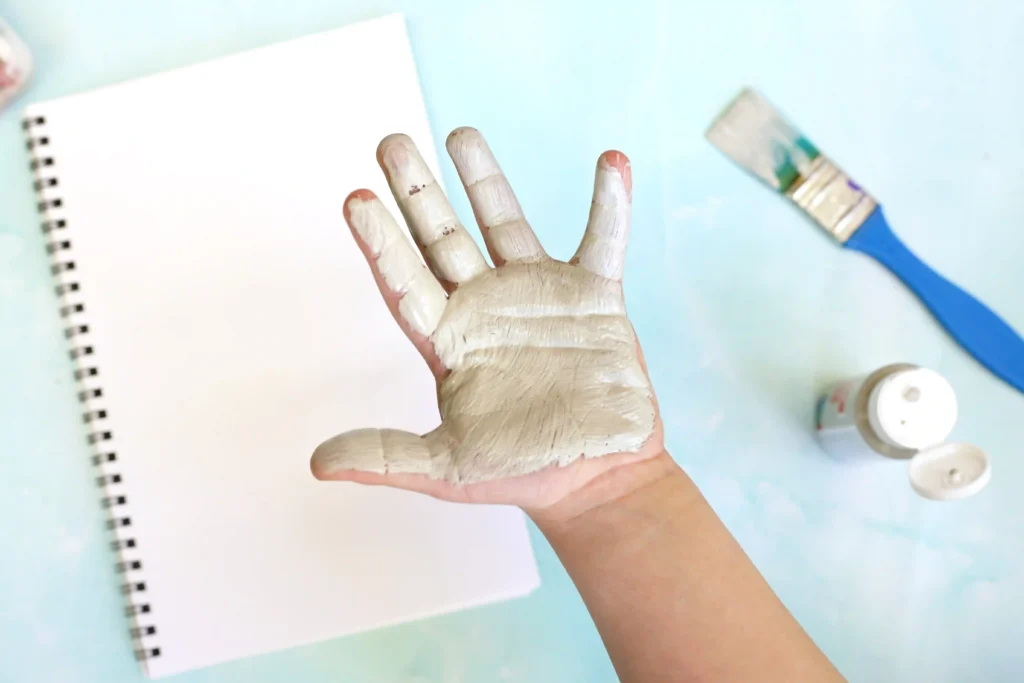 Letter E Elephant Handprint Craft - Cultivating Brilliant Minds a child's hand painted gray for this elephant craft