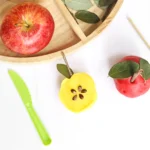 a Parts of an Apple Playdough Tray that uses playdough apple seeds, sticks, and leaves to create playdough apples