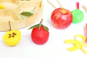 playdough in a ball with leaves and a stick to look like an apple