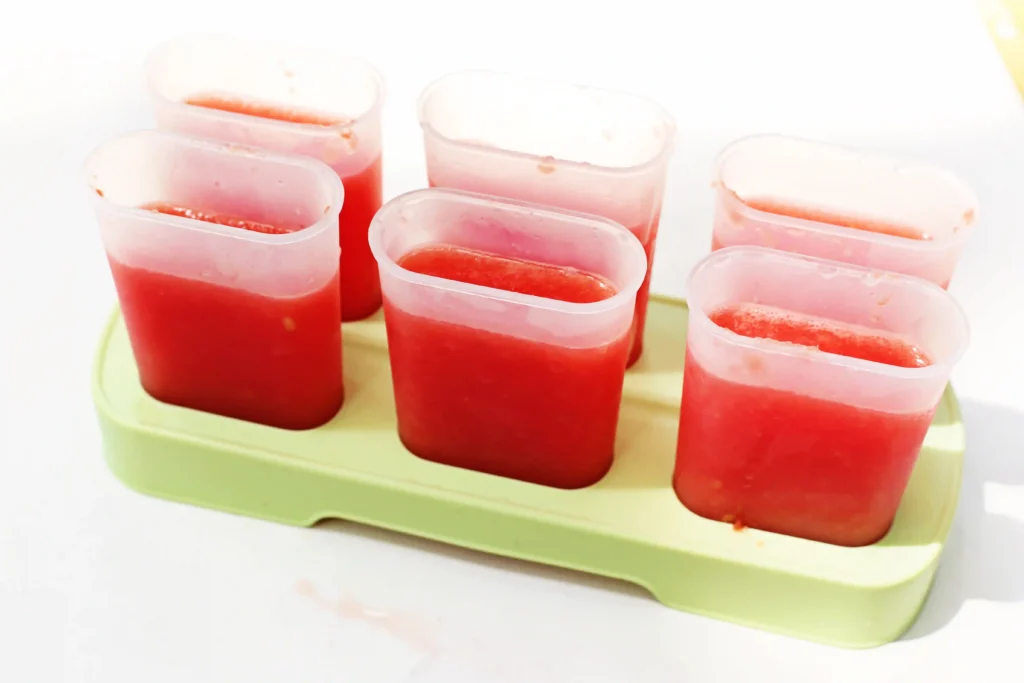 Watermelon Kiwi Popsicles - Cultivating Brilliant Minds popsicle molds filled with blended watermelon for this summer snack for kids